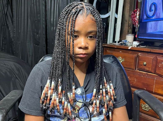 girl with black knotless braids with natural colored beads